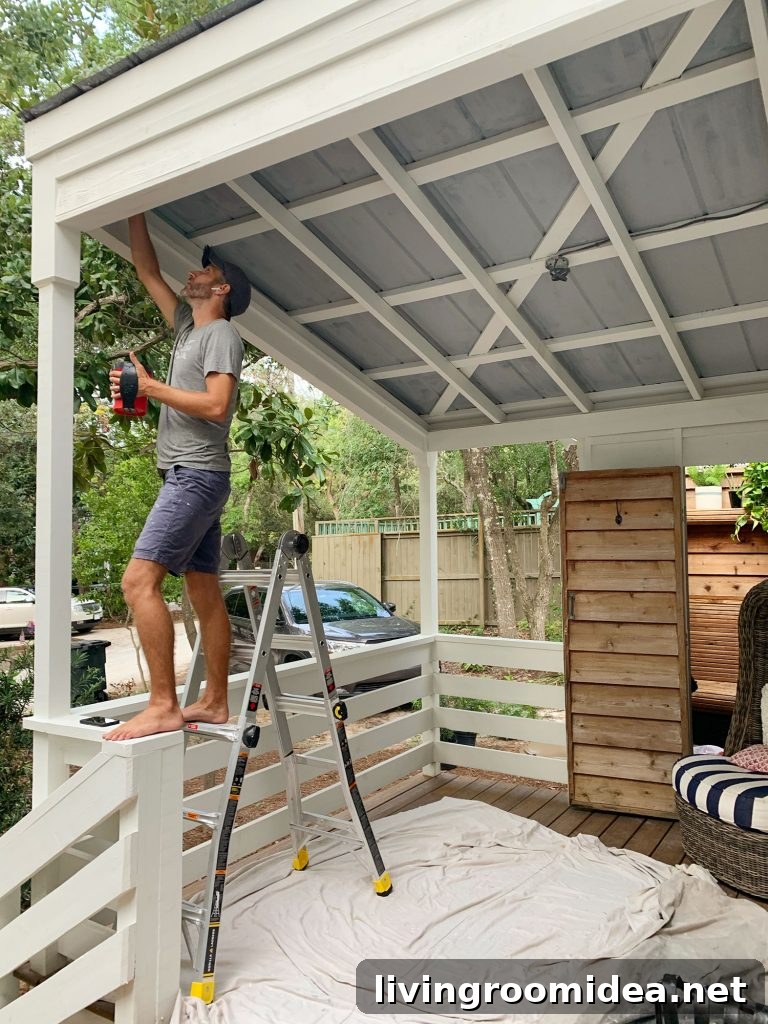 John Standing On Ladder Priming Metal Porch Ceiling
