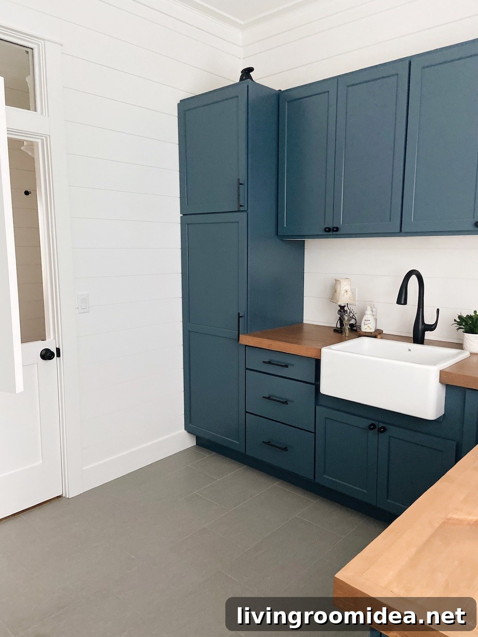 Shingle-Style Beach House Tour in Seabrook, WA 24 Laundry room with moody blue cabinets