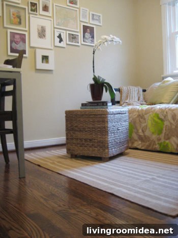 clean hardwood floor with dash & albert striped rug and woven wicker ottoman with orchid