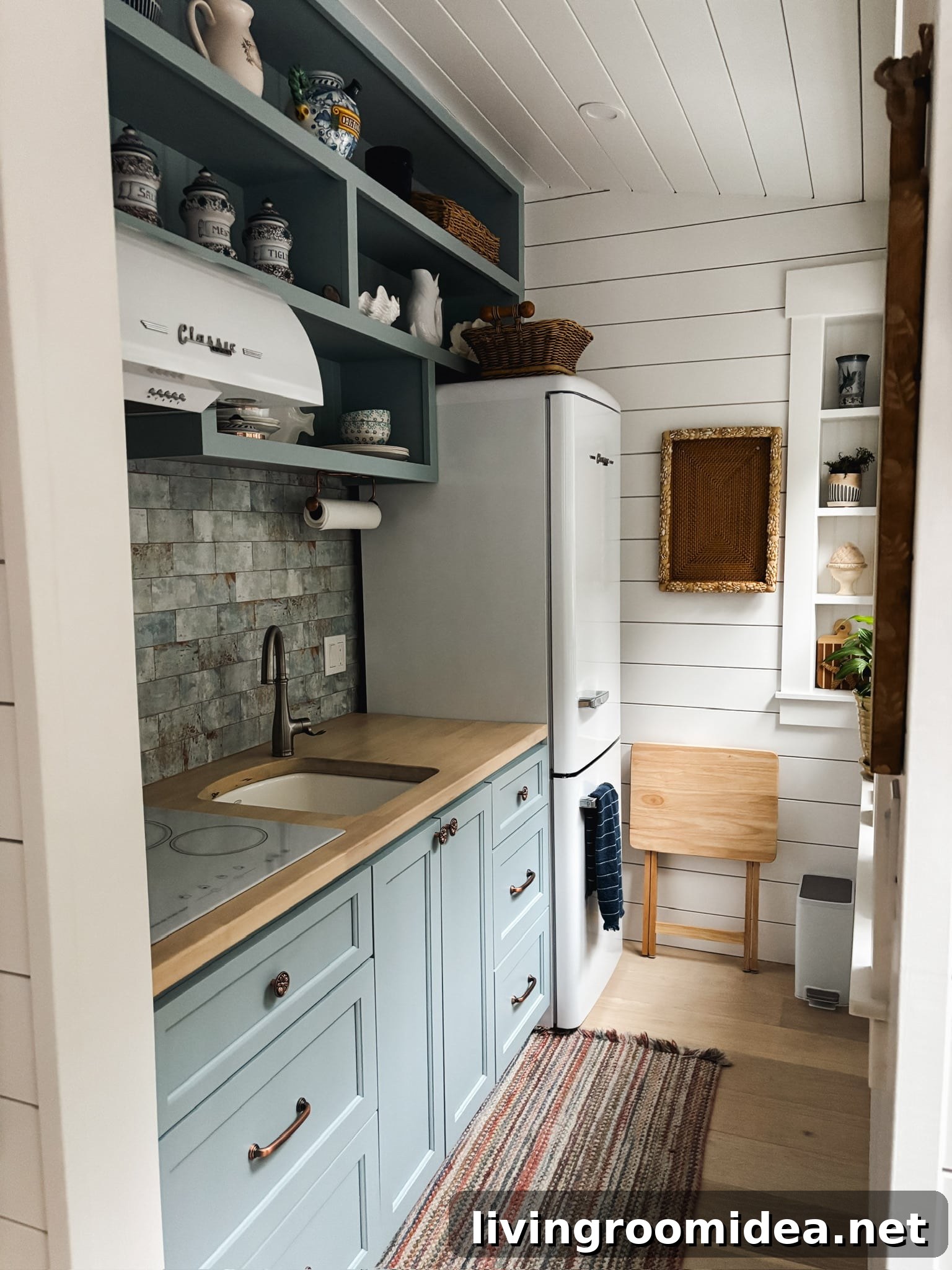 Tiny cottage kitchen with blue cabinets and tile wall