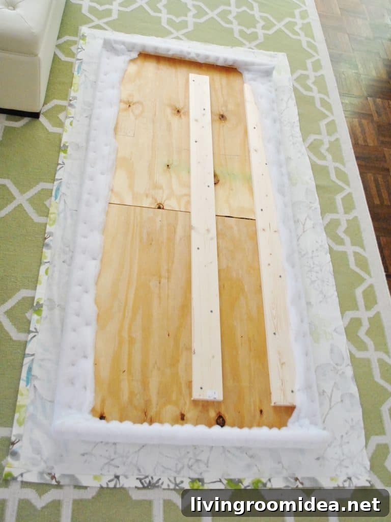 Fabric and headboard frame laid out to begin upholstery