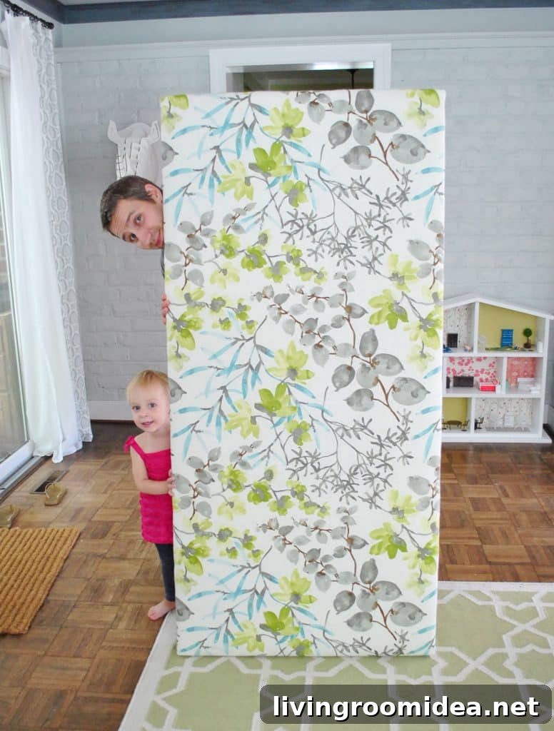 John standing with finished DIY fabric headboard 