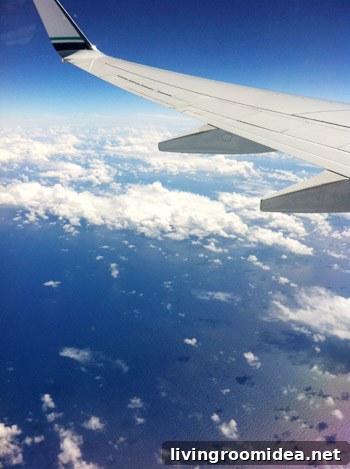 airplane wing over ocean with clouds