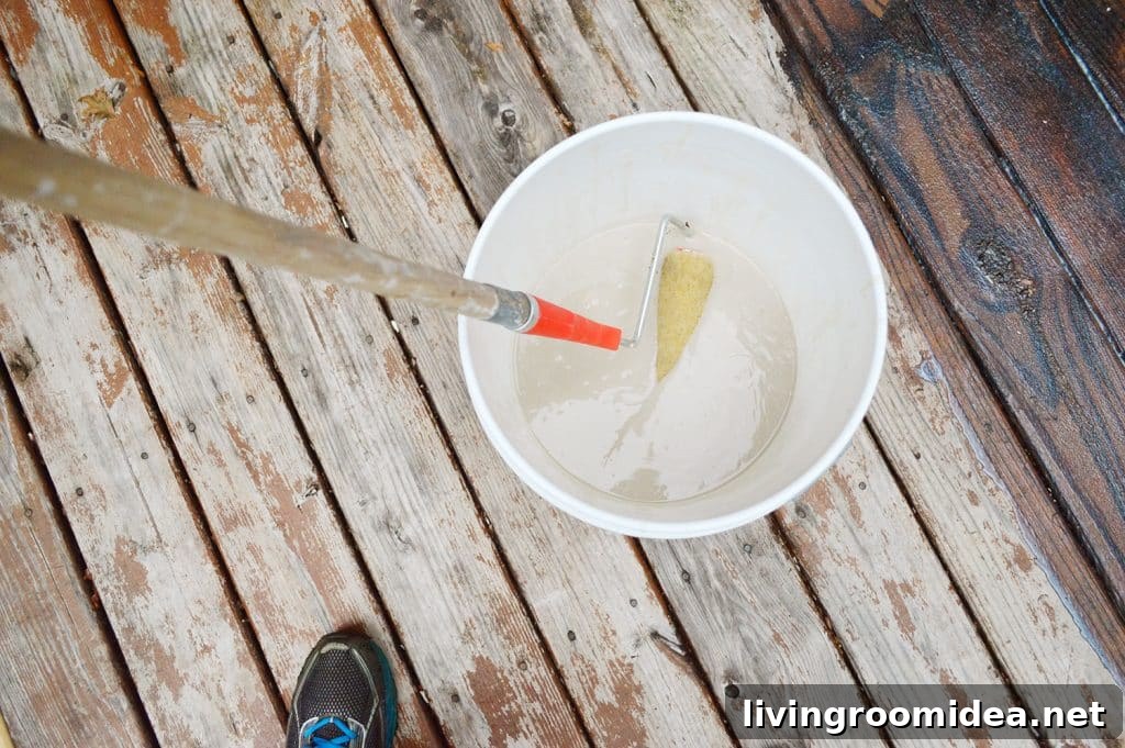 How to Strip a Deck for Staining: Step-by-Step Guide 9 Dipping paint roller into bucket of deck stain stripper