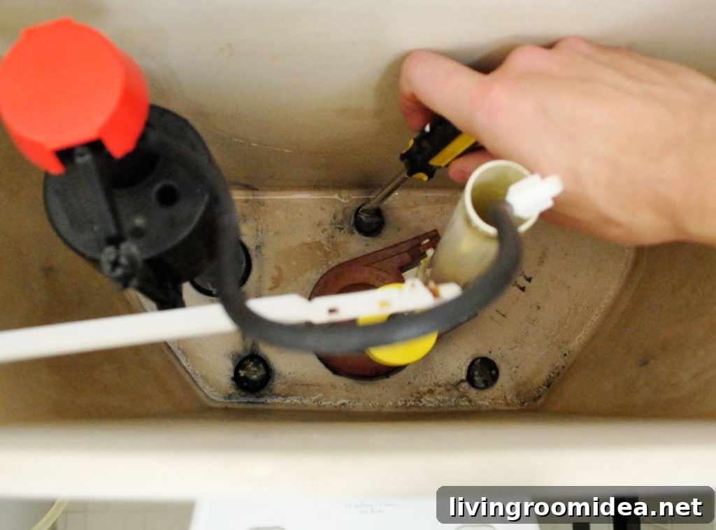 Hand Unscrewing Bolts Inside Toilet Tank