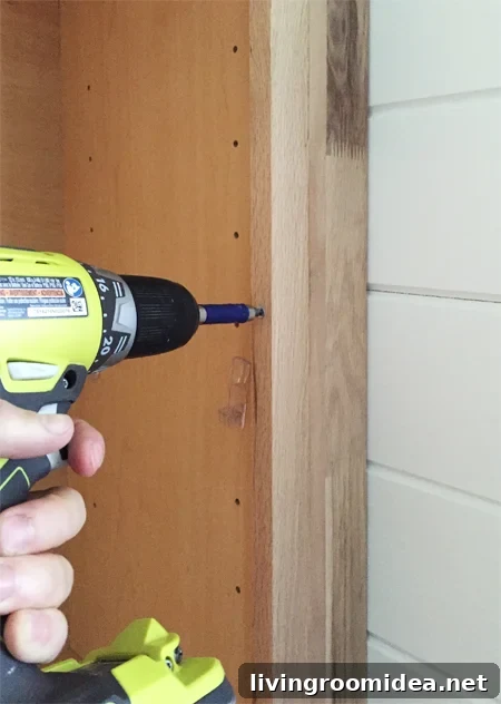Screwing filler piece next to base cabinet for bookshelves
