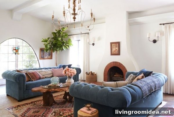 White living room with blue chesterfield sofas - design by Emily Henderson