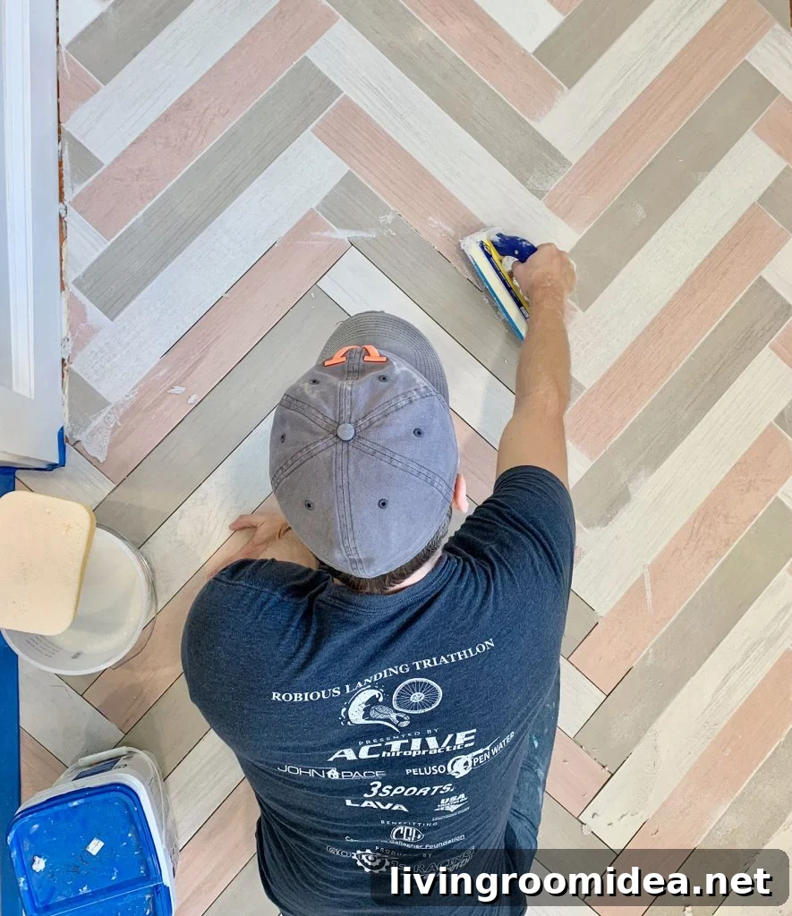 John grouting a colorful herringbone mudroom floor with mapei grout