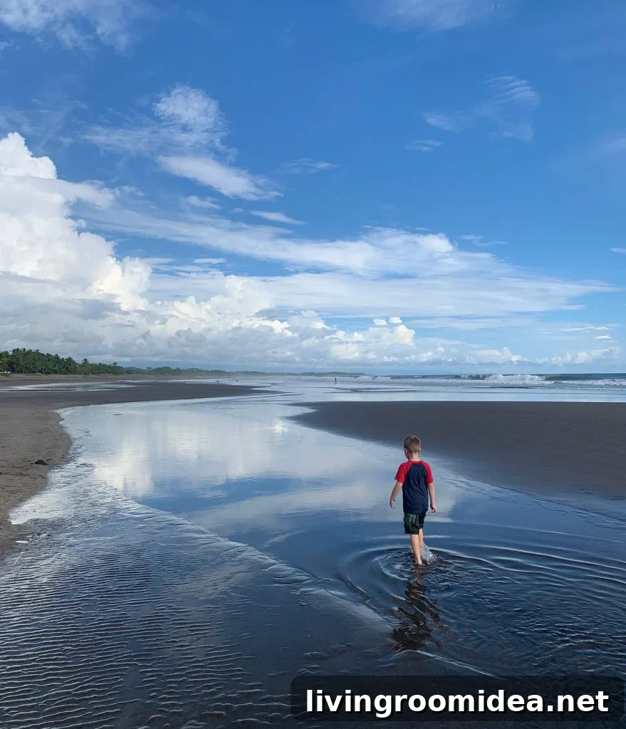 Young Boy Playing In Tide Pool at Esterillos Oeste Beach In Costa Rica