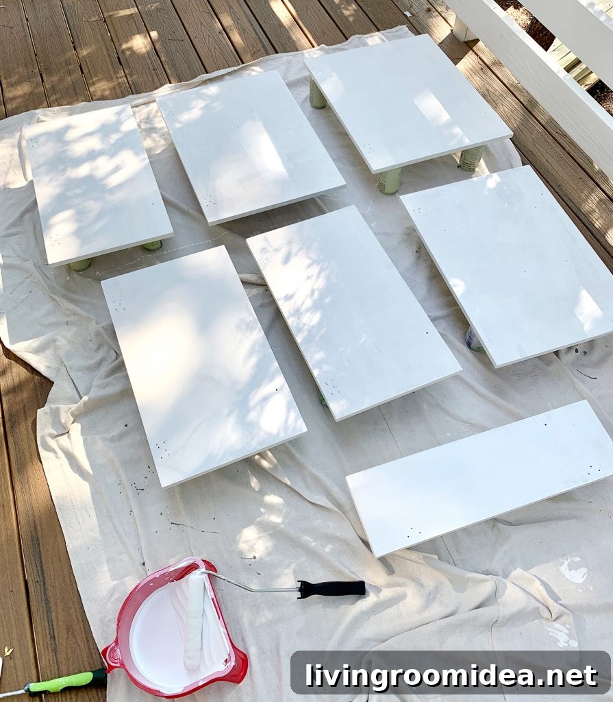 Cabinet doors laid on drop cloth with coat of white primer drying