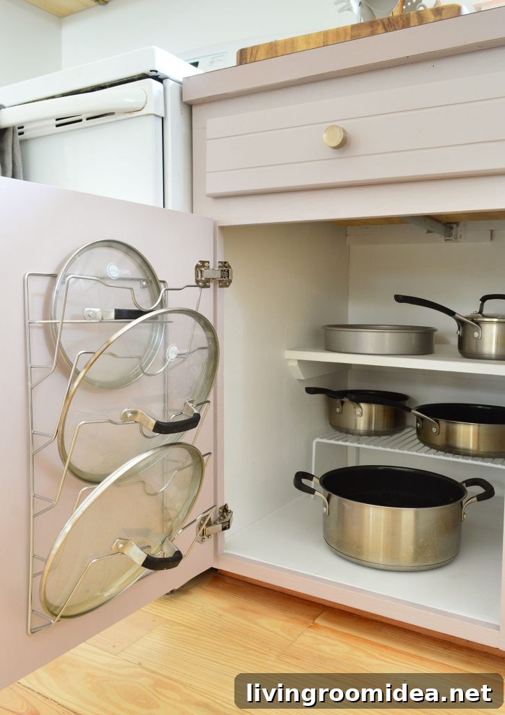Pots and pans organized in small kitchen with lid mounted on cabinet door