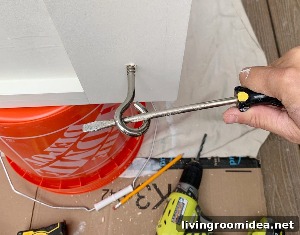 Turning eyehook in hanging daybed using long screwdriver